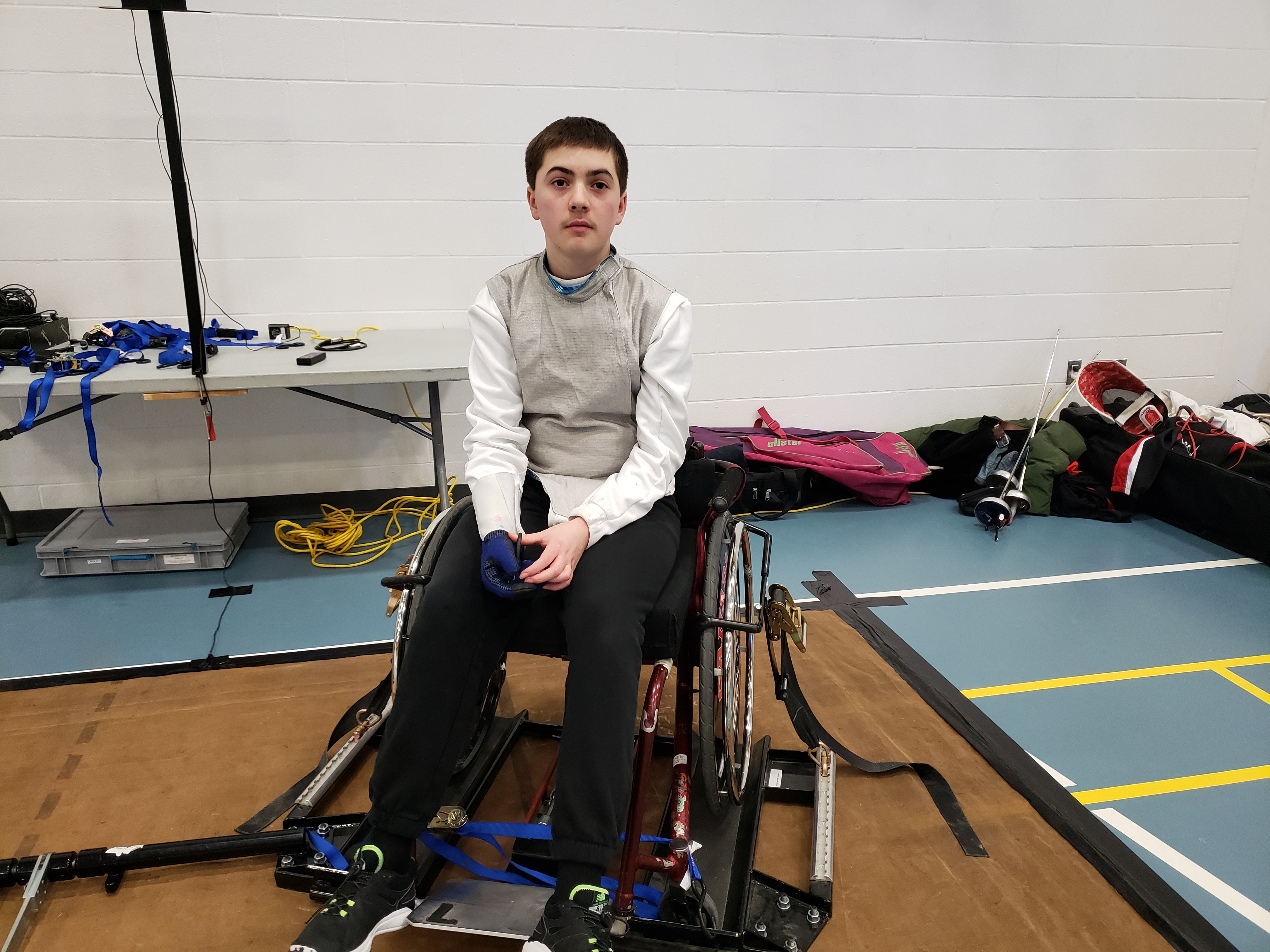 Kai in his fencing gear and his altered wheelchair 