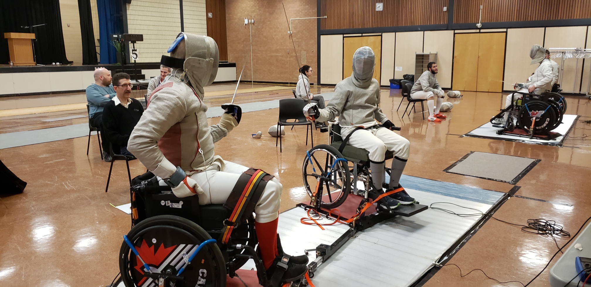 two people fencing in wheelchairs facing each other